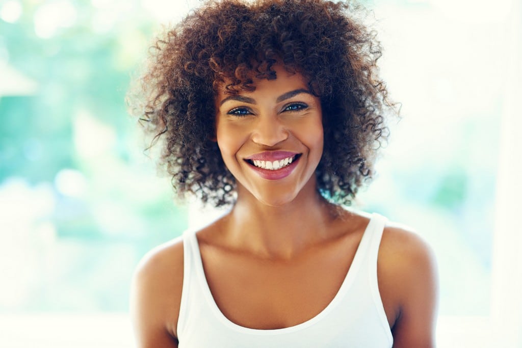 Brunette woman with short curly hair in hair transition 