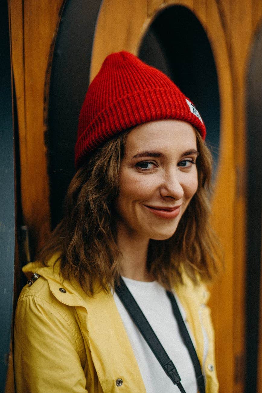 Model uses red hat as accessories to show off her look with wavy hair