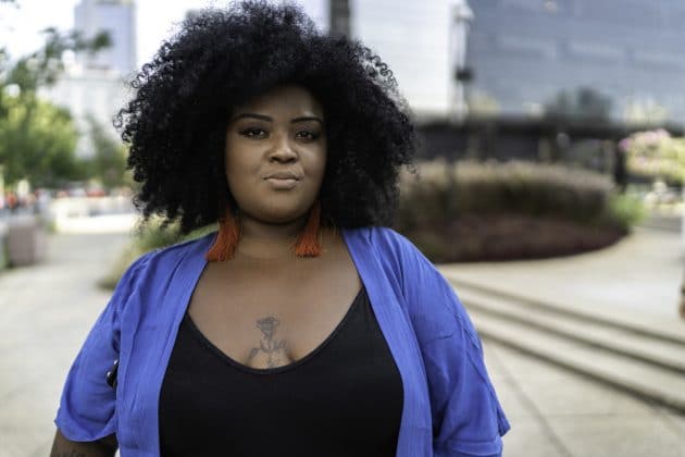 Woman with curly hair in bluish black color.