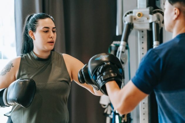 man and woman practicing fighting with boxing gloves